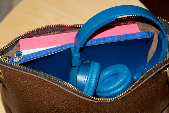 Open female bag with headphone and accessories in it