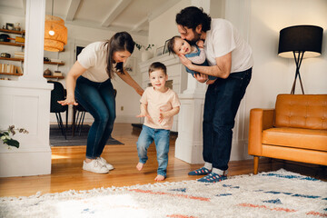 happy family with young child and baby having a dance party