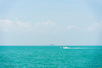Small motorboat on the ocean in Key Biscayne, Florida with a hazy sky