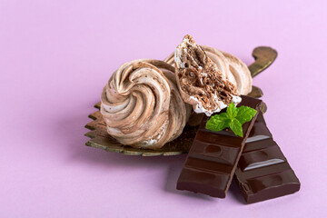 Meringues with dark chocolate close up.
