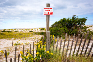 A Keep Off sign and fence on fragile sand dunes