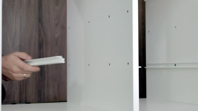 Installation of a drawer on guides in a cabinet. Furniture assembler by handyman.