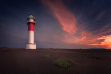 Fangar Lighthouse in the Ebro Delta, Tarragona, at sunset with colorful warm clouds in the sky