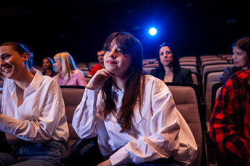 Young girl is watching a movie in cinema.