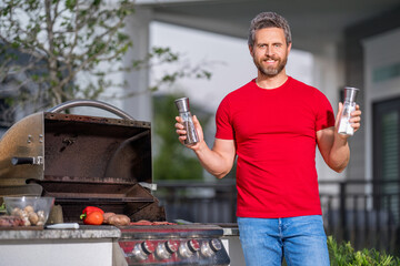 Man at a barbecue grill. Male cook preparing barbecue outdoors. Bbq meat, grill. Roasted beef....