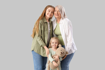 Little girl with her mom and grandmother on light background