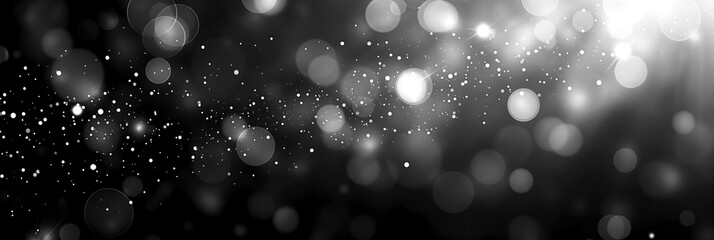 Monochrome silver bokeh lights on a black abstract background. Black and white blurred light particles in a mystical setting. Elegant grayscale bokeh for sophisticated graphic designs