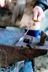 Blacksmith in a forge at work on an anvil. Hot metal forging
