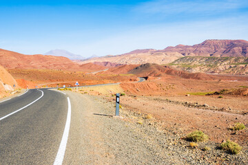 Empty paved asphalt road in Atlas mountains with high peaks and desert arid landscape near Tizi n'Tichka pass, Morocco, North Africa