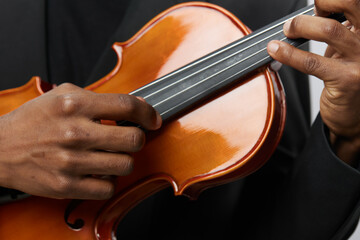 Close up of man in suit playing violin on white background, artistic performance concept for music...