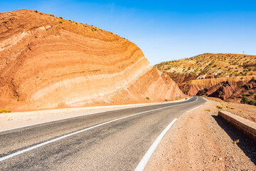 Empty paved asphalt road in Atlas mountains with high peaks and desert arid landscape near Tizi...