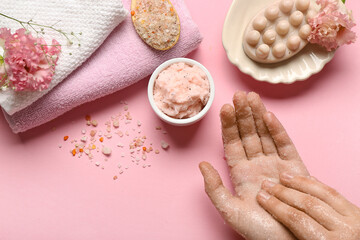 Woman applying natural scrub onto her hands on pink background, closeup