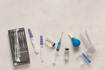 Gynecological speculum with pap smear tools, pregnancy tests and ampules on white grunge background