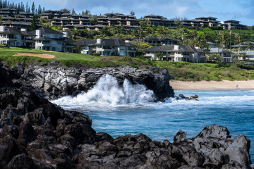 Tropical vacation resort, tourist villas on a hillside, blue Pacific Ocean and waves crashing on...