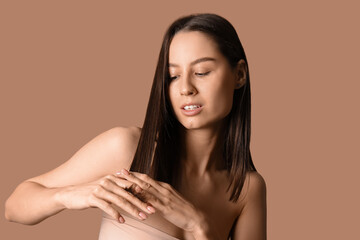 Young dark-haired woman on beige background