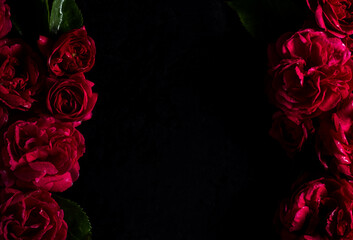 Moody flowers. Floral frame. red roses on a black background. Blur and selective focus. Low key photo. Flat lay, copy space. Top view - Powered by Adobe