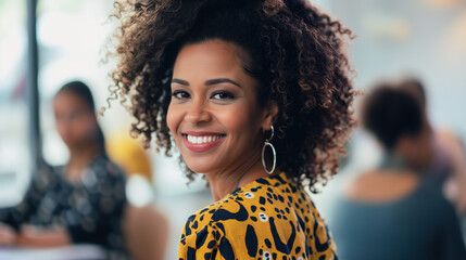  beautiful smiling black woman with curly hair wearing a leopard print dress standing in an office meeting room, with people working behind her at a table.  - Powered by Adobe