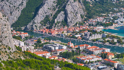 Naklejka premium AERIAL: Scenic drone view of the residential area of Omis next to Cetina river.