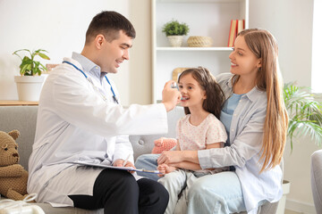 Little girl with her mother and doctor using inhaler at home