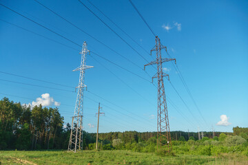 Obraz premium Power lines running through the forest. The support of an overhead power line. Natural landscape and technological progress.