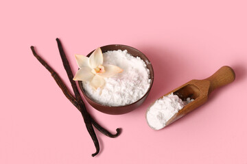 Bowl of vanilla powder and sticks on pink background