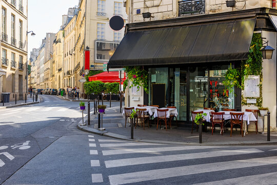 Cozy street with tables of cafe  in Paris, France. Cityscape of Paris. Architecture and landmarks of Paris