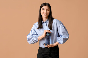 Young Asian woman holding bottle of water on white background