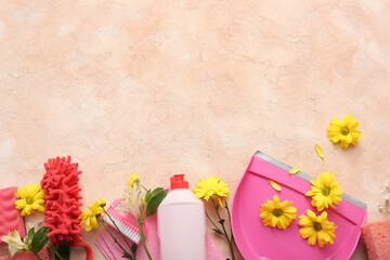 Set of cleaning supplies and spring flowers on beige grunge background
