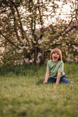 Fototapeta premium portrait of a child playing in an apple orchard in spring