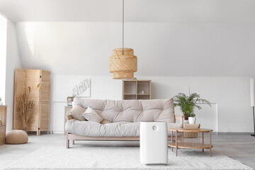 Modern humidifier near sofa in light living room