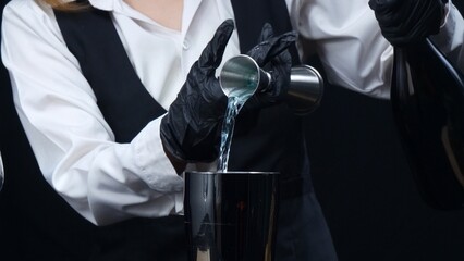 Macrography of skilled bartender hand measure syrup and pour it in to shaker. Close-up of process,...
