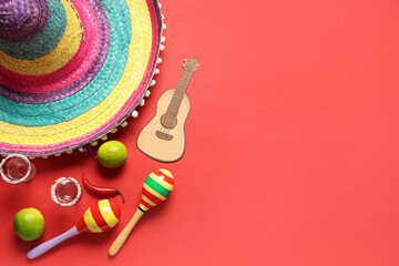 Mexican maracas with sombrero, tequila and paper ukulele on red background. Cinco de Mayo