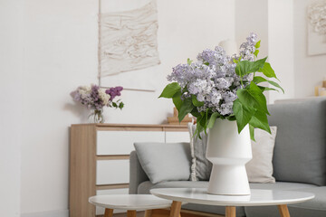 Vase with flowers on table in stylish interior of living room