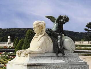 Angel sitting on the sphinx in the park of Versailles (France)