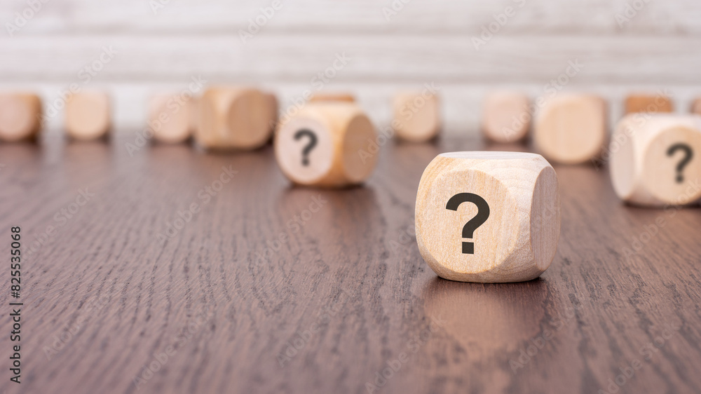 Poster question mark cube stand on wooden background with copy space.