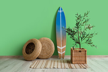 Surfboard with poufs and plant near green wall in room