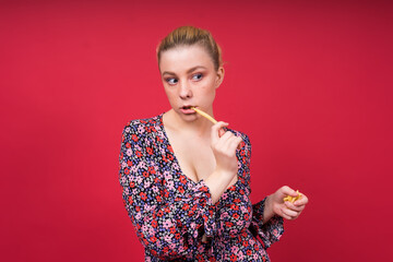 Young beautiful slender female eating french fries. Concept of un healthy fat junk and healthy food