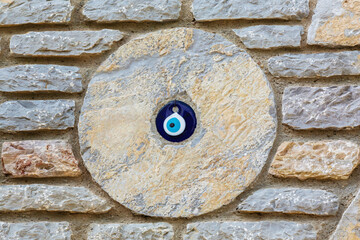 ?Stone wall with embedded evil eye talisman for protection and decoration, capturing cultural and...