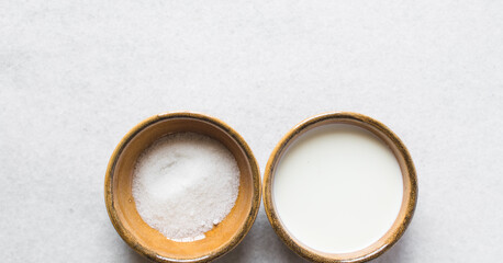 overhead view of milk cream and sugar, mise en place of ingredients for making caramel sauce, process of making caramel