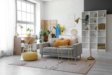 Interior of living room with sofa, workplace and surfboard