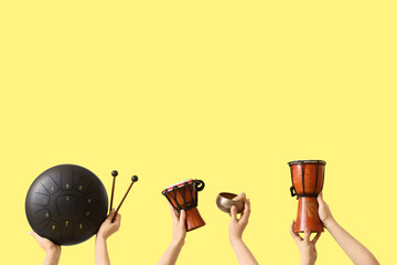 Women with glucophone, Tibetan singing bowl and drums on yellow background