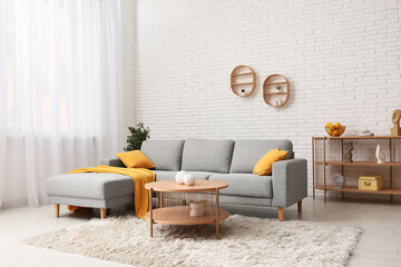 Interior of living room with grey sofa, coffee table and pillows
