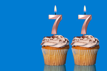 Birthday Cupcakes With Candles Lit Forming The Number 77.