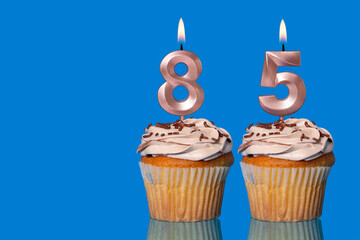 Birthday Cupcakes With Candles Lit Forming The Number 85.