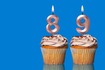 Birthday Cupcakes With Candles Lit Forming The Number 89.