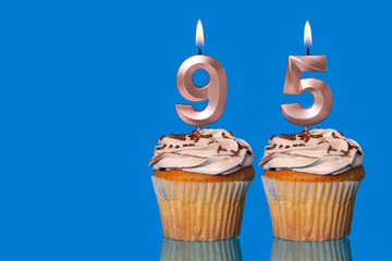 Birthday Cupcakes With Candles Lit Forming The Number 95.