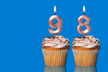 Birthday Cupcakes With Candles Lit Forming The Number 98.