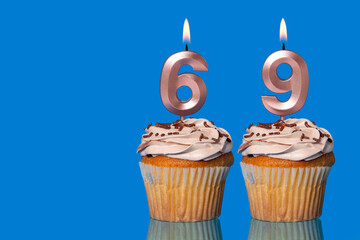 Birthday Cupcakes With Candles Lit Forming The Number 69.
