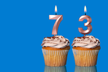 Birthday Cupcakes With Candles Lit Forming The Number 73.