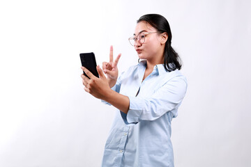 Portrait of asian woman in formal dress using mobile phone for interaction video calling by showing two fingers. Isolated on white background